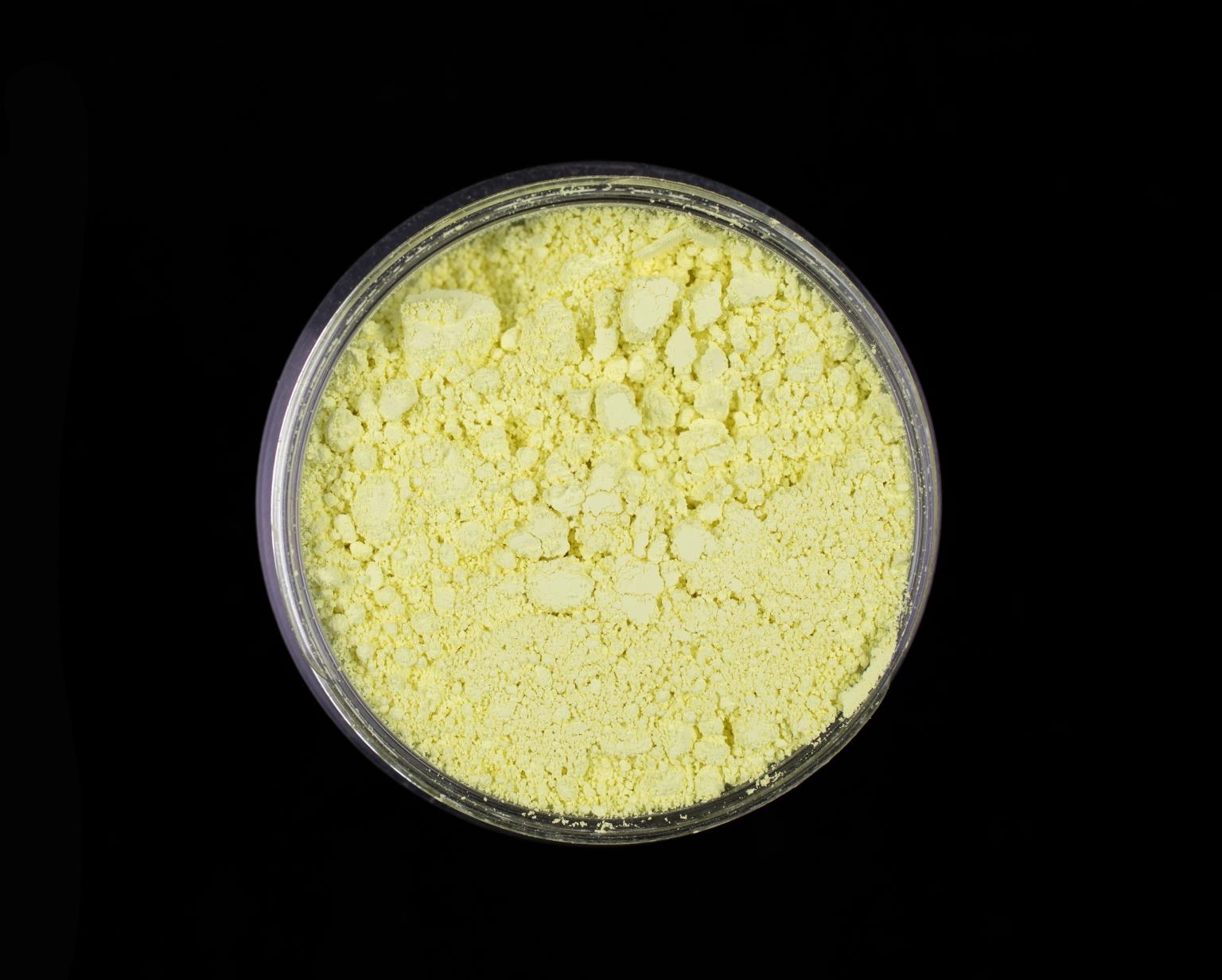 Circular jar of light yellow pigment powder.