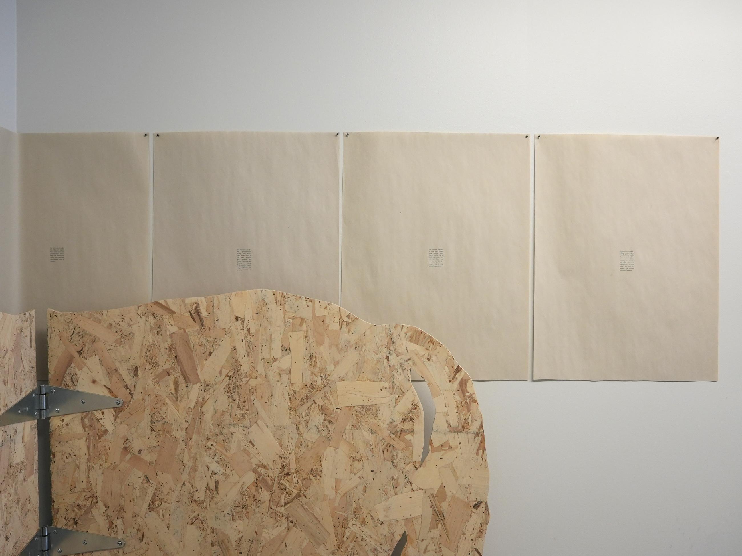 life-size silhouettes of horses made from plywood, hinged, with printed text on paper lined up on wall