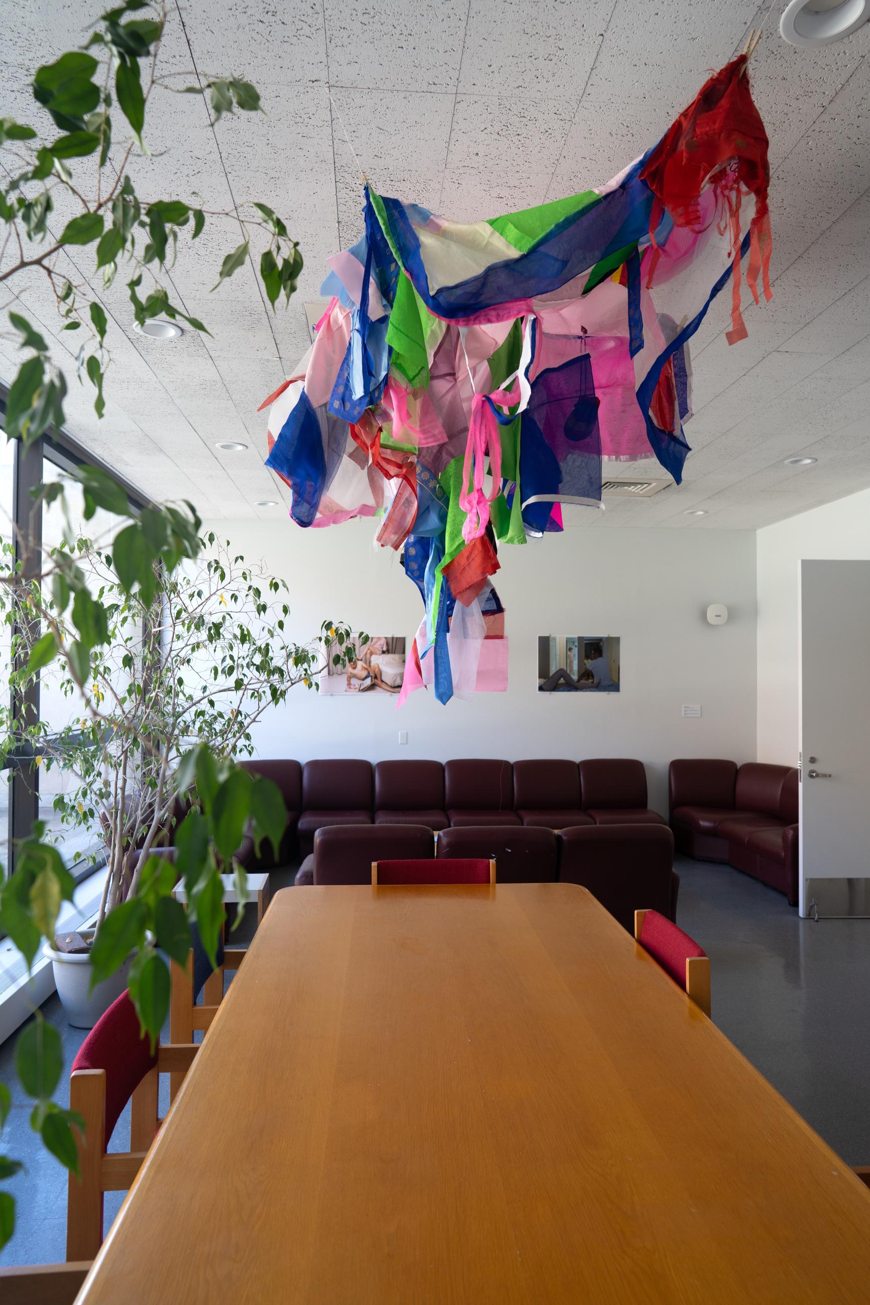 Colorful pieces of fabric hung from the ceiling over a table