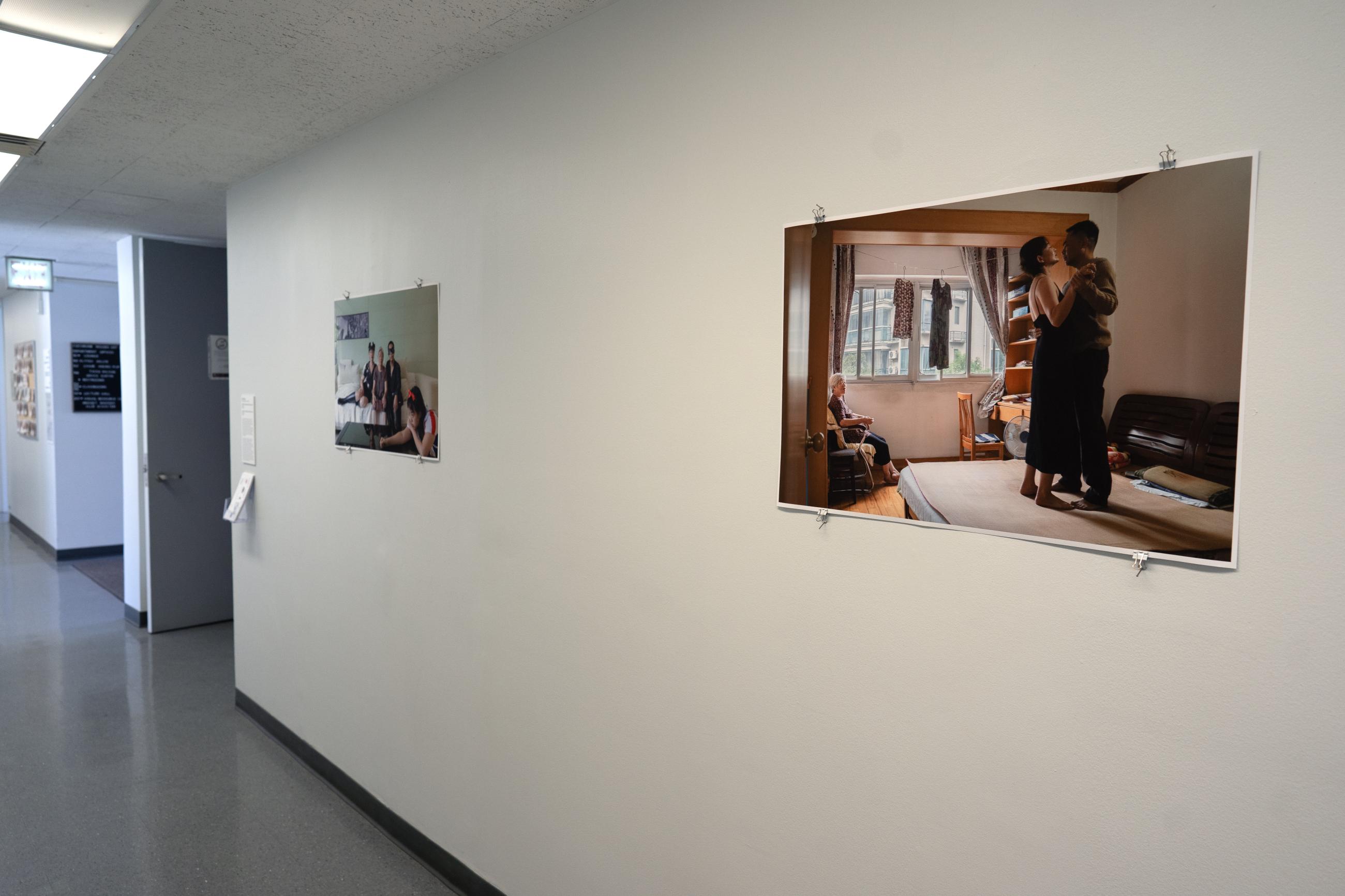Two large printed photographs hung on a white wall