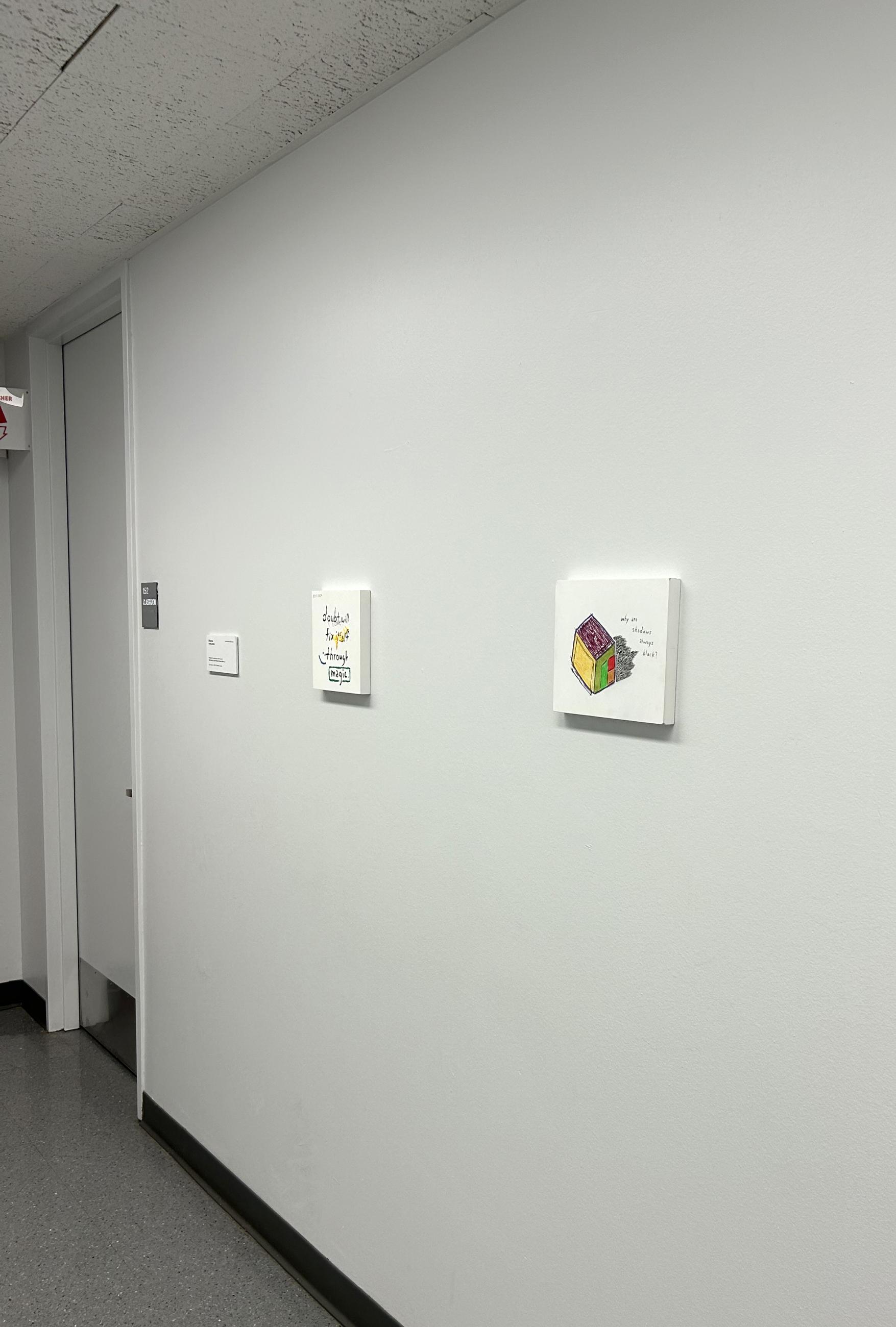 Two small paintings on a white wall