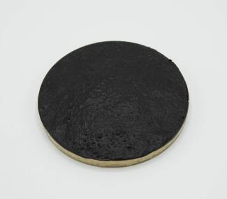 Small, round concrete disc painted black